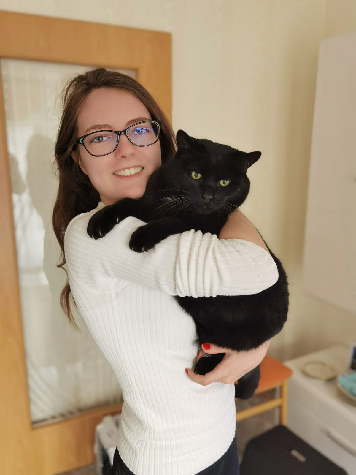 Linda vom Pfotenservice Rinkerode hält liebevoll eine schwarze Katze im Arm